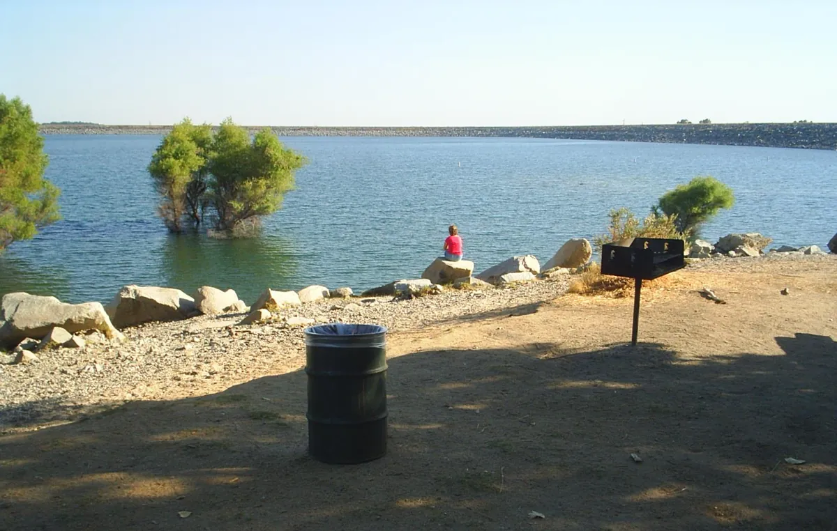 Calm blue water on Folsom Lake with the dam in the distance