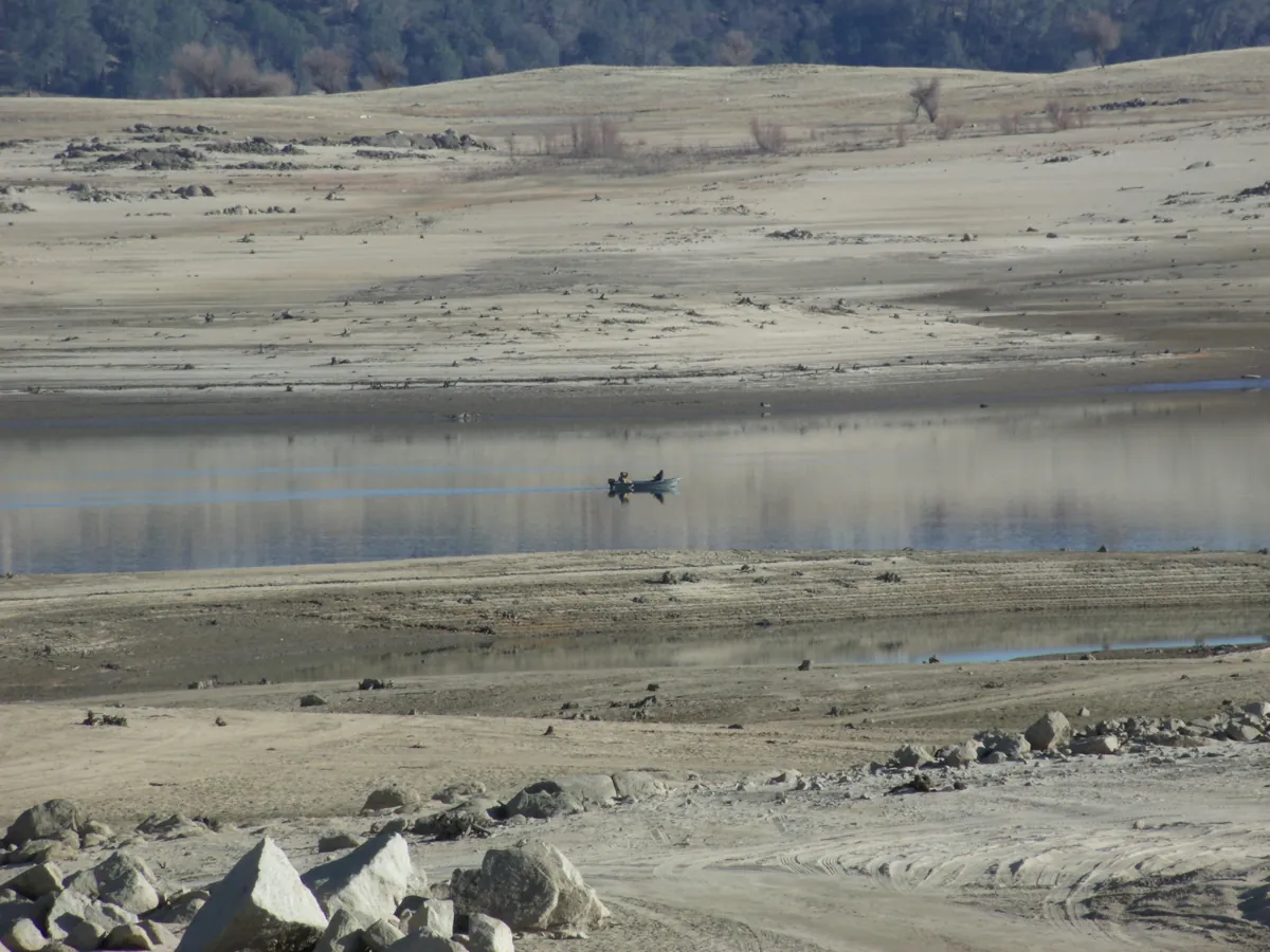 A lone motorboat sitting on the flat water of Folsom Lake