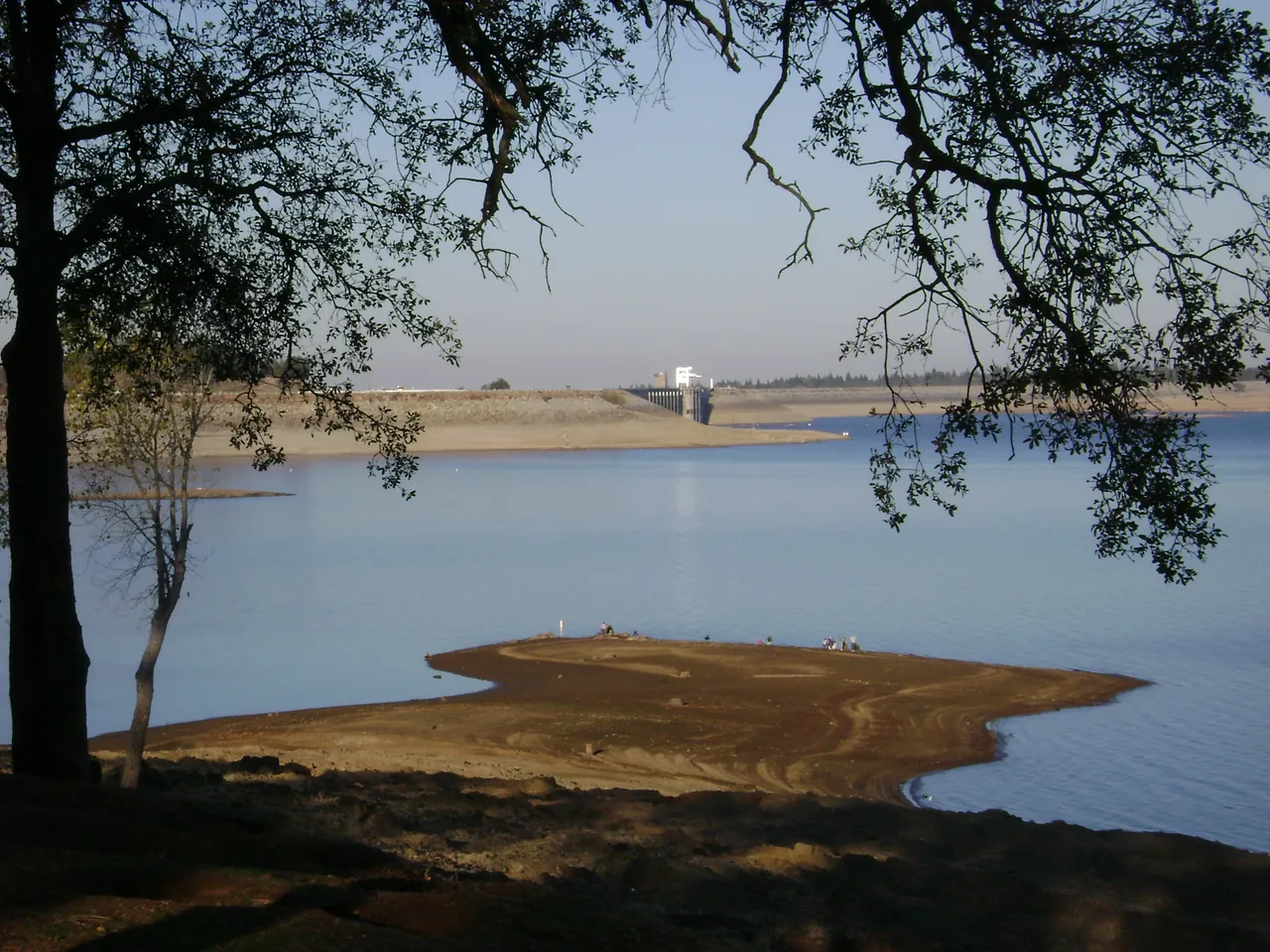 Folsom Lake with the dam and spillway in the distance and a low-water shoreline